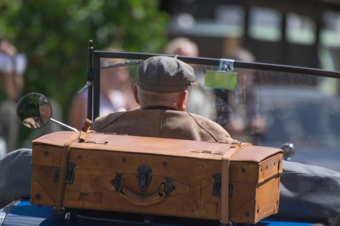 Älterer Mann in Auto mit Vintage-Koffer