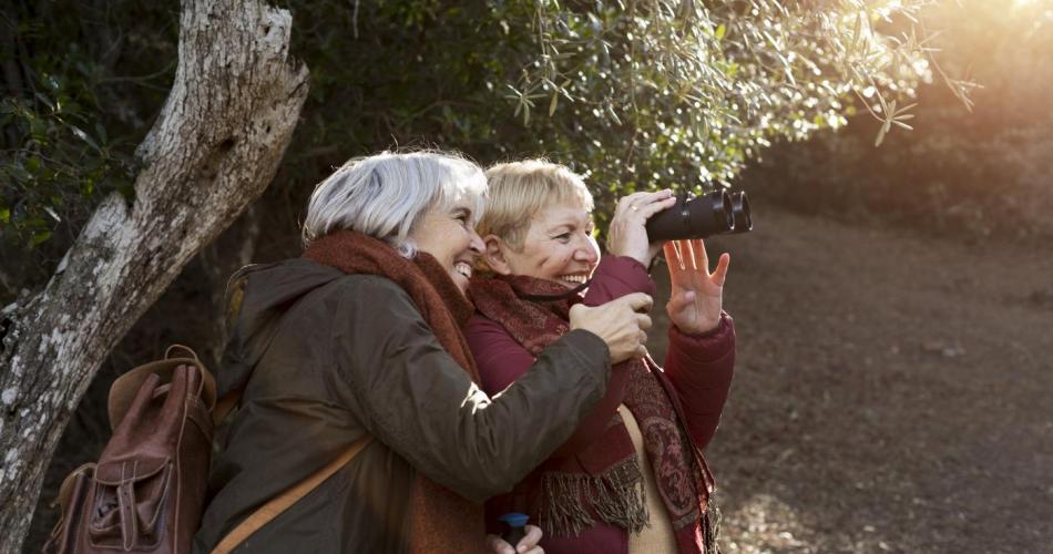 Seniorinnen schauen durch ein Fernglas